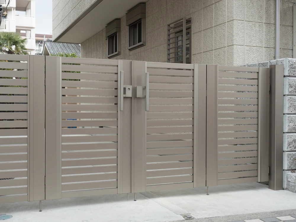 Entrée extérieure d'une résidence moderne avec portail et clôture en aluminium gris