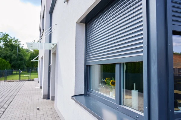 Façade extérieure moderne avec terrasse en bois et pelouse